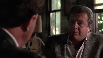 Two Men In Suits Are Talking To Each Other In A Living Room . GIF