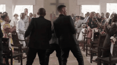 Two Men In Suits Are Walking Down A Church Aisle GIF