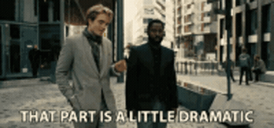 Two Men In Suits Are Walking Down A Street And One Of Them Is Saying That Part Is A Little Dramatic . GIF