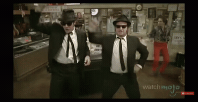 Two Men In Suits Dancing In Front Of Hill Joint Sign GIF