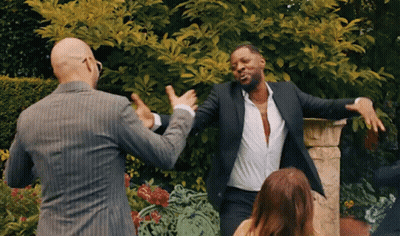 Two Men In Suits Dancing With Woman In Garden GIF