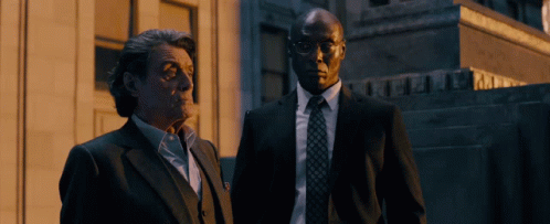 Two Men In Suits In Front Of A & A Building GIF