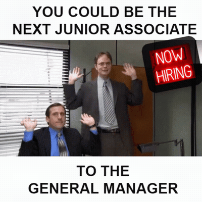Two Men In Suits In Front Of Now Hiring Sign GIF