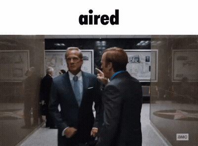 Two Men In Suits In Hallway With Word Aired GIF