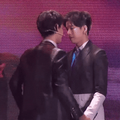 Two Men In Suits Kissing On Stage GIF