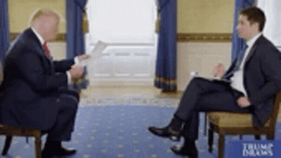 Two Men In Suits Sitting And Talking GIF