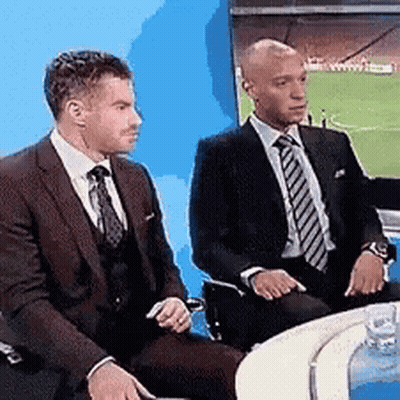 Two Men In Suits Sitting At Soccer Field GIF