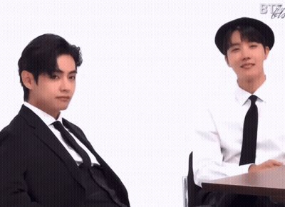 Two Men In Suits Sitting At Table With BTS GIF