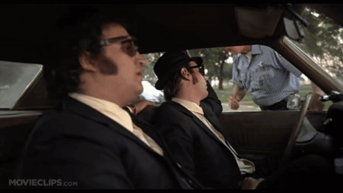 Two Men In Suits Sitting In Car With Movieclips.com GIF