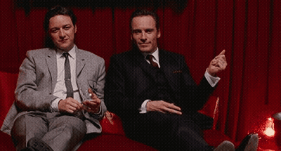 Two Men In Suits Sitting On Couch With Champagne GIF