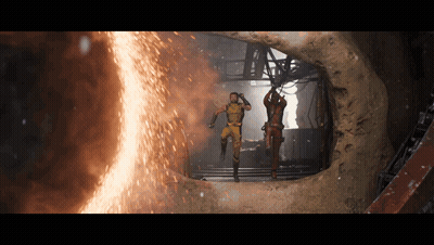 Two Men In Suits Standing In Front Of Fire GIF