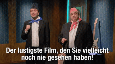 Two Men In Suits Standing Together With Der Lustigste Film Den Sie Vielleicht Noch Nie Gesehn Ha GIF