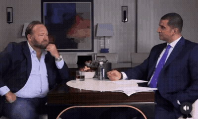 Two Men In Suits Talking At Table GIF