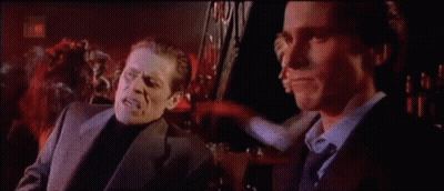 Two Men In Suits Talking In Dark Room GIF