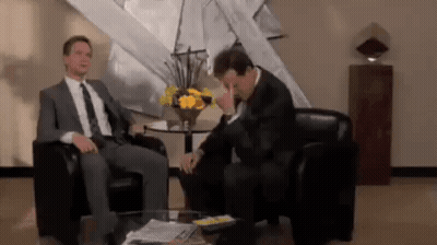 Two Men In Suits Talking In Living Room GIF