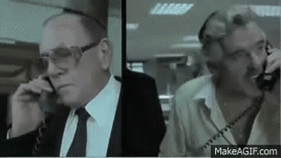Two Men In Suits Talking On Phones GIF