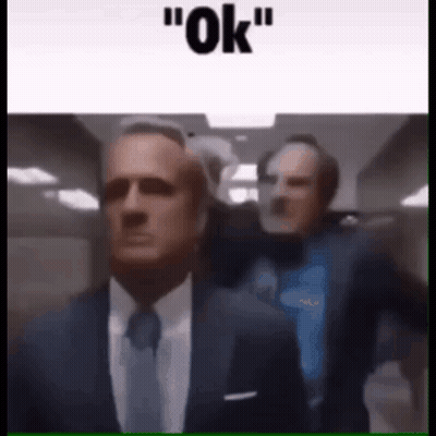 Two Men In Suits Walking Down Hallway Saying Ok GIF