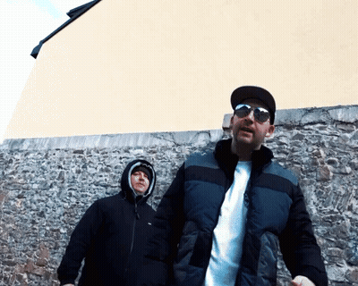 Two Men In Sunglasses In Front Of Stone Wall GIF
