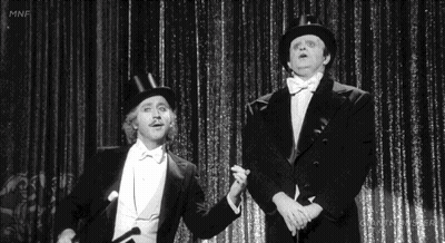 Two Men In Tuxedos And Top Hats On Stage GIF