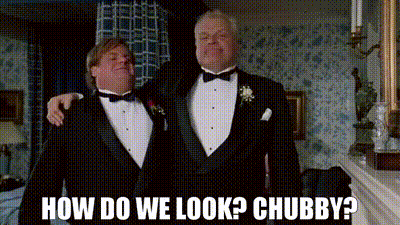 Two Men In Tuxedos Are Standing Next To Each Other And One Of Them Is Asking How Do We Look ? Chubby ? GIF
