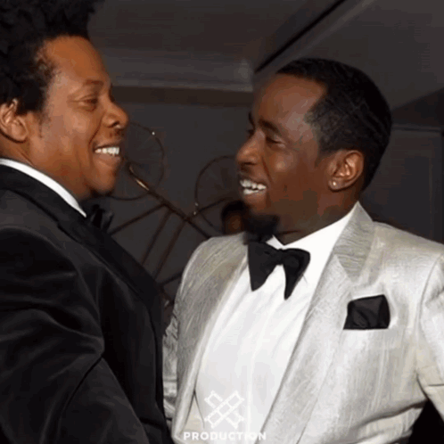 Two Men In Tuxedos Are Standing Next To Each Other And The Word Production Is On The Bottom Of The Picture GIF