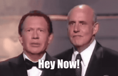 Two Men In Tuxedos Are Standing Next To Each Other With The Words Hey Now Written On Their Faces GIF