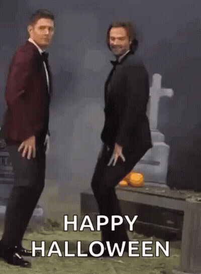 Two Men In Tuxedos Dancing At Cemetery Saying Happy Halloween GIF