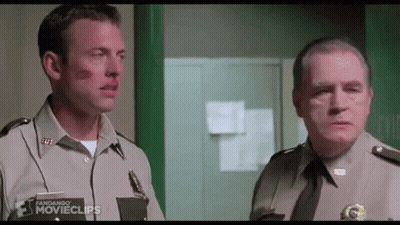 Two Men In Uniform Are Standing Next To Each Other In A Hallway . GIF