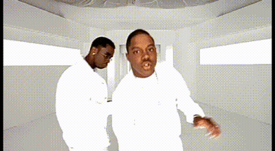 Two Men In White Shirts Are Dancing Together In A White Room GIF