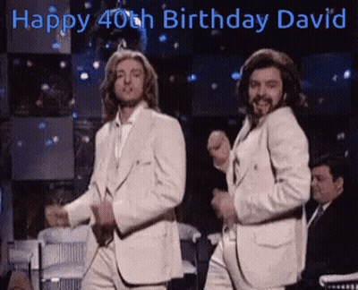 Two Men In White Suits Dancing In Front Of Happy 40Th Birthday David Sign GIF