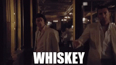 Two Men in White Suits Walking Down Whiskey Hallway