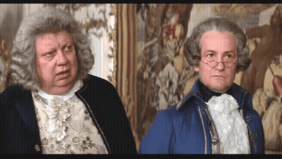 Two Men In Wigs Standing Next To Each Other GIF