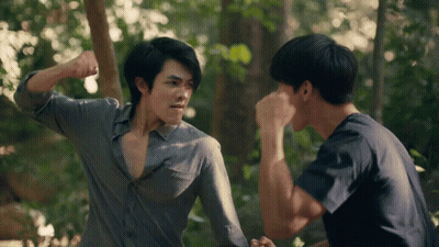 Two Men In Woods One Holding Fist Up GIF