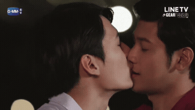 Two Men Kissing in Front of Line TV Screen