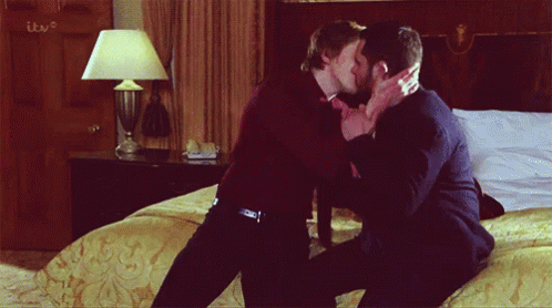 Two Men Kissing In Front Of TV GIF