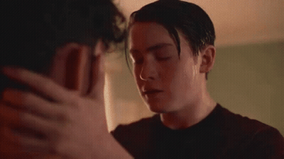 Two Men Kissing In Room With Flowers GIF