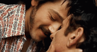 Two Men Kissing One Wearing Floral Shirt GIF