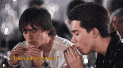 Two Men Kissing With The Words Kisses Passionately In The Corner GIF