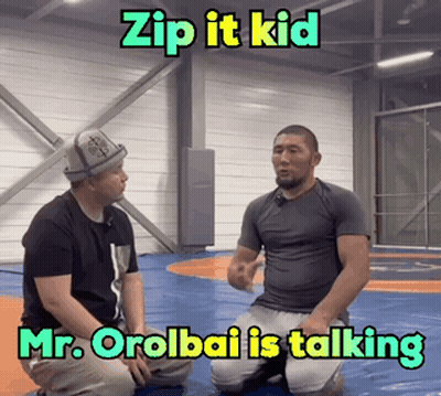 Two Men Kneeling On Wrestling Mat Talking GIF