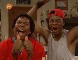 Two Men Laughing And Thumbs Up In Living Room GIF
