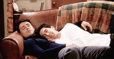 Two Men Laying On Couch Heads Together GIF