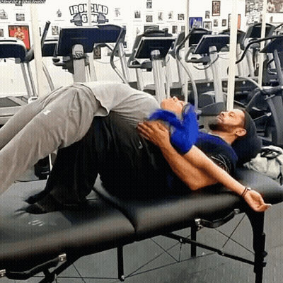 Two Men Laying On Gym Bench With Iron Clad Sign GIF