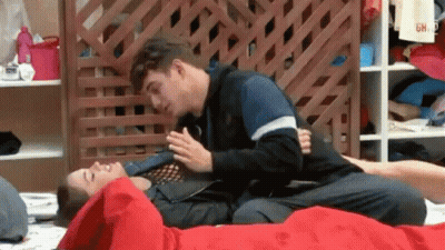Two Men Laying On Top Of Each Other On Bed With Wooden Fence GIF
