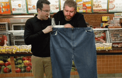 Two Men Looking At A Pair Of Jeans In A Subway Store GIF