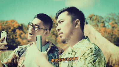 Two Men Looking At Cell Phones With Chinese Writing GIF