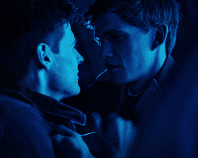 Two Men Looking At Each Other In Dark Room GIF