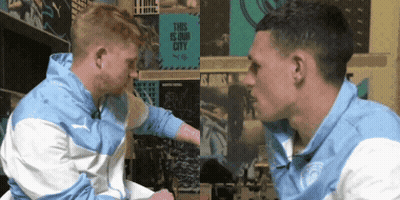 Two Men Looking At Each Other In Front Of This Is Our City Sign GIF