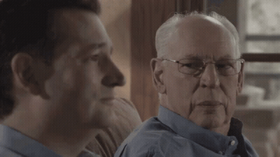 Two Men Looking At Each Other One With Glasses GIF