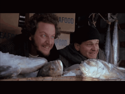 Two Men Looking At Fish Beside Seafood Box GIF