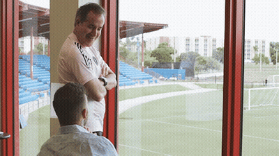 Two Men Looking Out Window At Field GIF